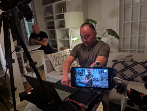 sangdo practicing with a portable controller while being filmed for a livestream, with smartphone camera mounted on a tripod
