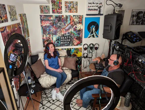 Podcast recording session with Phil Anthony and GriffinGrrl in a home studio decorated with Seattle House Mafia artwork and DJ equipment