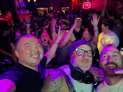 Seattle House Mafia in the booth with the crowd cheering and hands in the air behind them