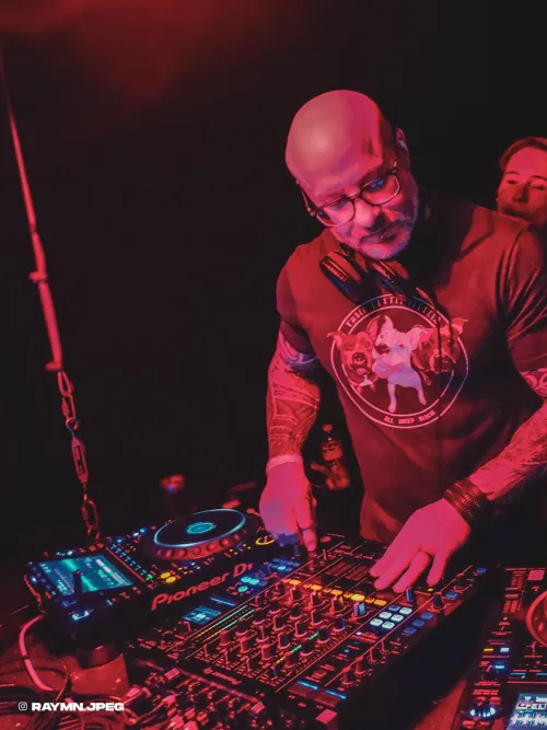 Phil Anthony DJing at Flammable washed in glowing red light